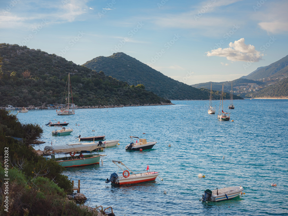 Small fishing boats at sunset time - Kas Turkey. Boats and mountains on Turkish Mediterranean coast, Popular tourist destination