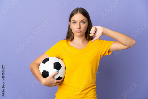Young Lithuanian football player woman isolated on purple background showing thumb down with negative expression © luismolinero