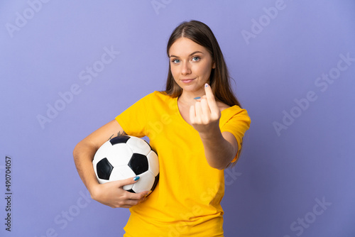 Young Lithuanian football player woman isolated on purple background doing coming gesture © luismolinero