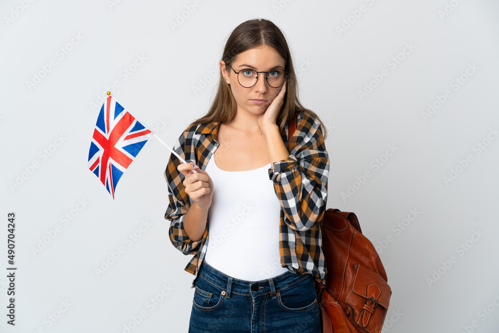 Young Lithuanian woman holding an United Kingdom flag isolated on white background frustrated and covering ears Young Lithuanian woman holding an United Kingdom flag isolated on white background frustrated and covering ears