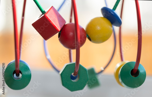 circle Bead Maze three green polygons and a sphere - a toy for children - blurred background