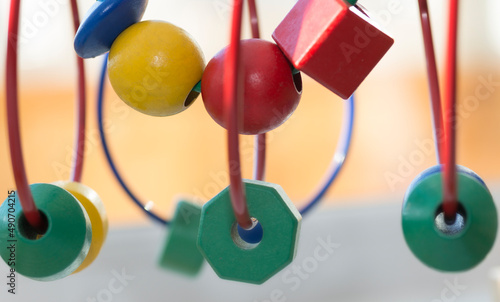 circle Bead Maze three green polygons and a sphere - a toy for children - blurred background