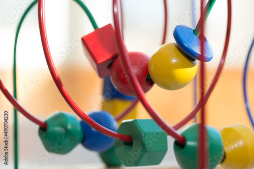 colored blocks on a spiral - circle Bead Maze - educational toy for children, background in the theme of child development
