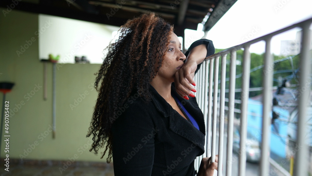 Fototapeta premium Thoughtful person standing by balcony thinking about life