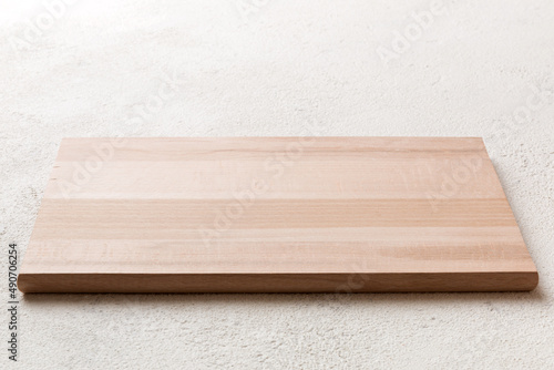 Perspective view of wooden cutting board on cement background. Empty space for your design