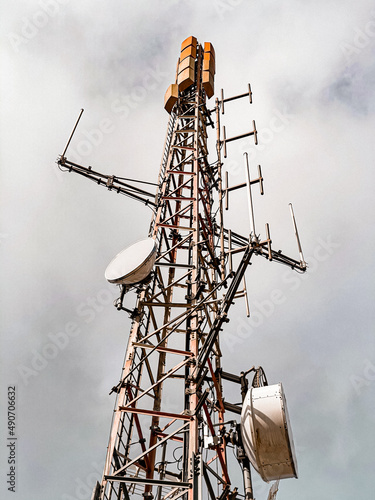 Telecommunication and mobile network infrastructure with two cell site towers side by side, housing antennas and Remote Radio Head, RRH, for greater coverage