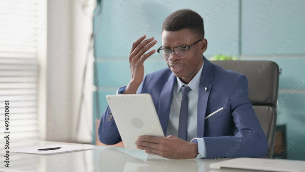 Young African Businessman Reacting to Loss on Tablet in Office Young African Businessman Reacting to Loss on Tablet in Office