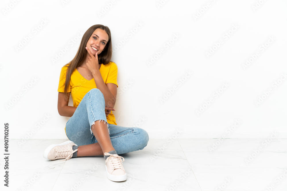 Young girl sitting on the floor smiling Young girl sitting on the floor smiling