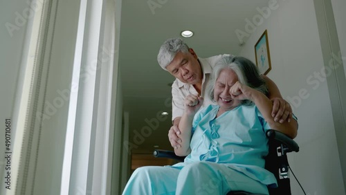 elderly woman with psychiatric symptoms is in a wheelchair with an elderly couple caring for her within a psychiatric hospital. concept of health problems
 photo