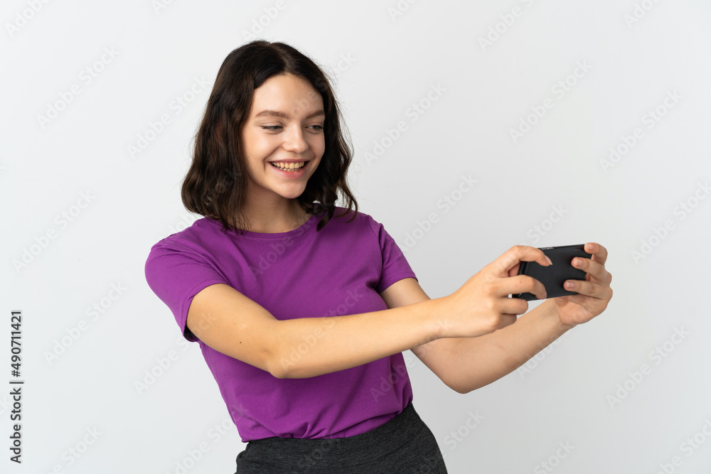 Teenager Ukrainian girl isolated on white background playing with the mobile phone Teenager Ukrainian girl isolated on white background playing with the mobile phone