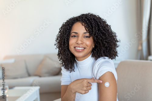 Covid-19 Vaccination. Portrait Of Happy Vaccinated African woman Showing Her Arm After Coronavirus Antiviral Vaccine Shot . Covid Immunization Campaign Concept.