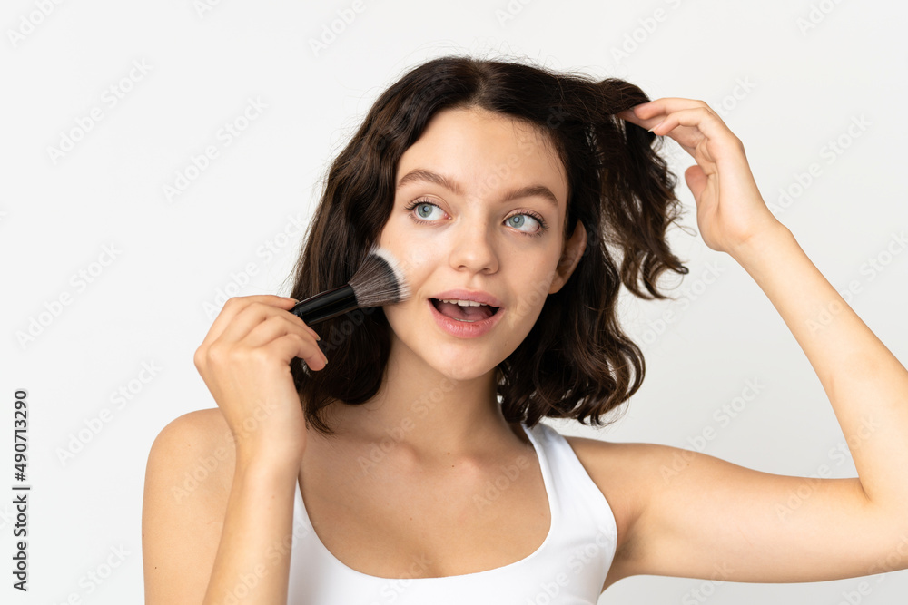 Teenager Ukrainian girl isolated on white background holding makeup brush Teenager Ukrainian girl isolated on white background holding makeup brush