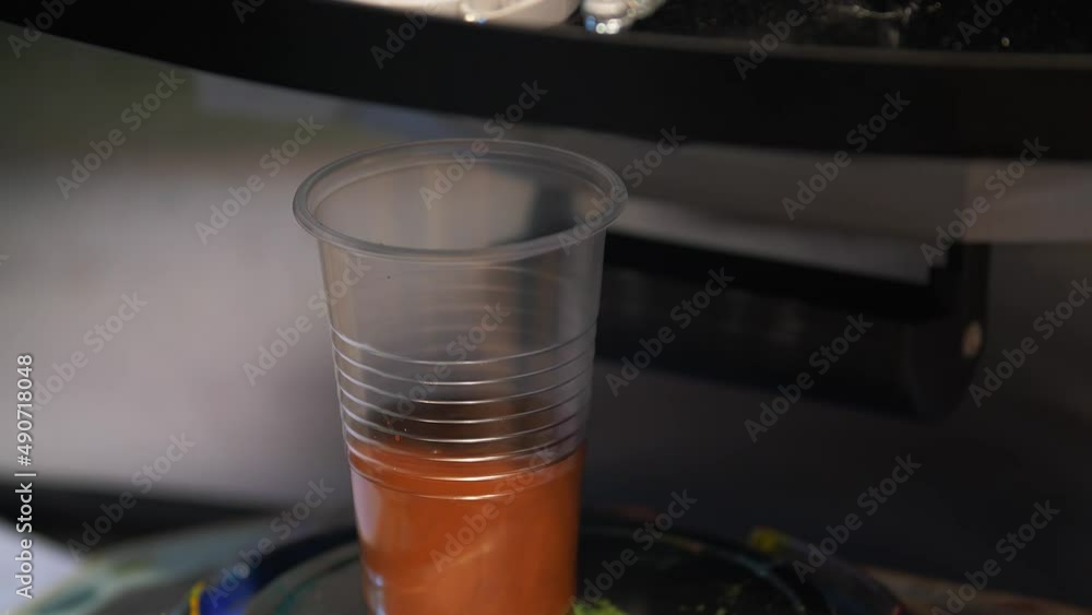 Feeding paint into a transparent glass close-up. Feeding paint into a transparent glass close-up.