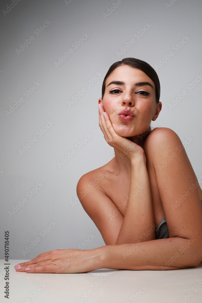 Fototapeta premium Beautiful young woman posing on white wall in the studio. Isolated.