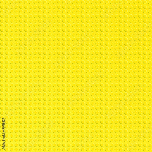 Yellow plastic constructor blocks plate. Abstract background
