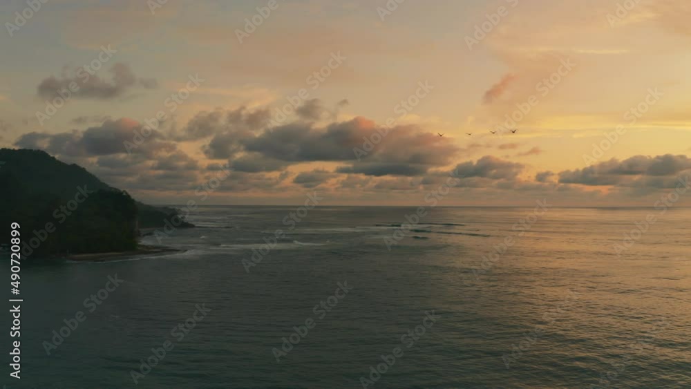 Aerial view overlooking calm sea, serene evening on the coast of Costa Rica - pan, drone shot Aerial view overlooking calm sea, serene evening on the coast of Costa Rica - pan, drone shot