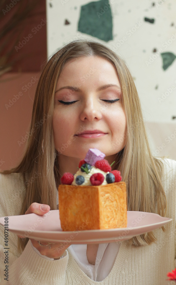 blond girl cube formed dessert with cream, raspberry, blueberry and marshmallow topping closeup photo