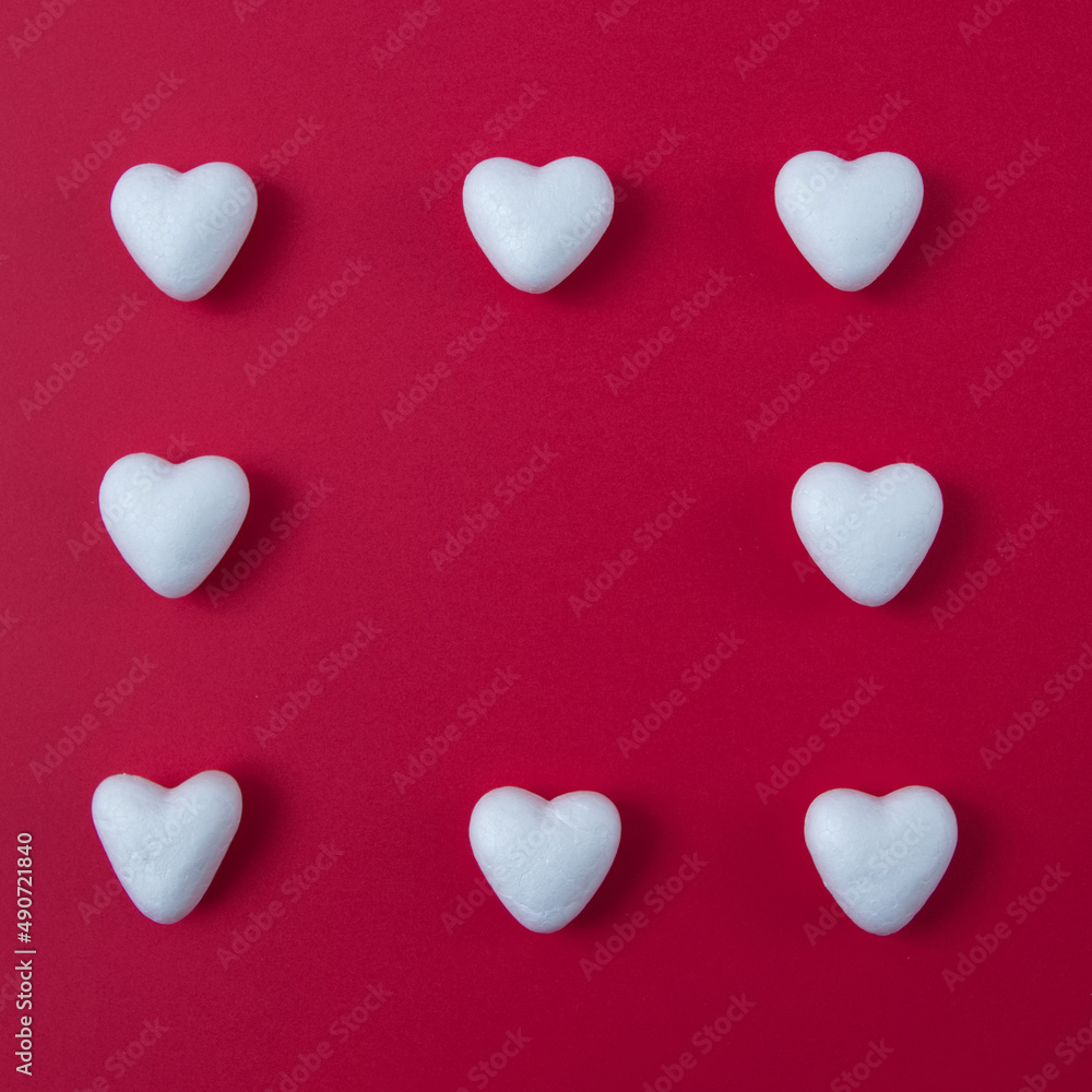White hearts on a red background form a square with copy space. Minimal love scene.