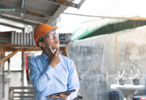 Young Asian foreman taking notes on his tablet, Business concept and technology.