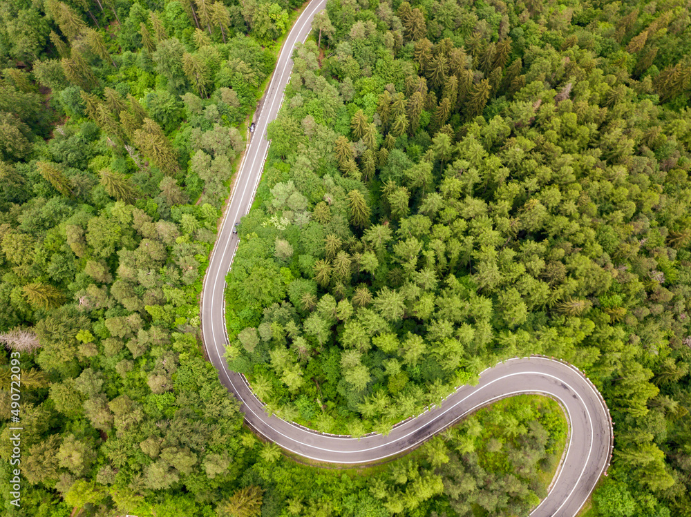 Winding road from high mountain pass, in summer time. Aerial view by drone . Romania Winding road from high mountain pass, in summer time. Aerial view by drone . Romania