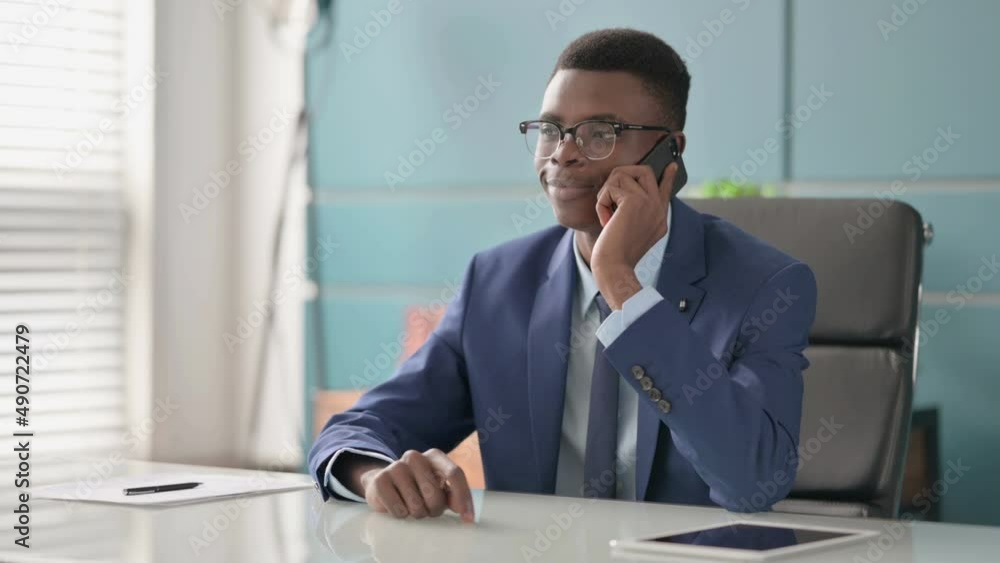 Young African Businessman Talking on Phone in Office Young African Businessman Talking on Phone in Office