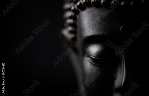 Meditating Buddha Statue on black background. Soft focus. Close up. Copy space. 