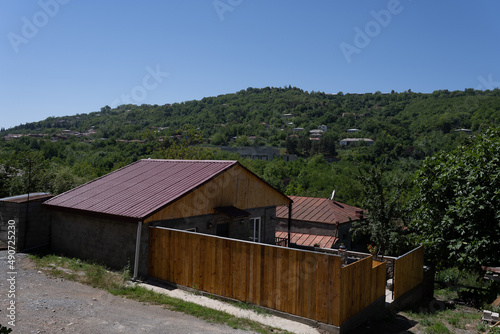 wooden building made of light boards with a red roof and a beautiful wooden fence.