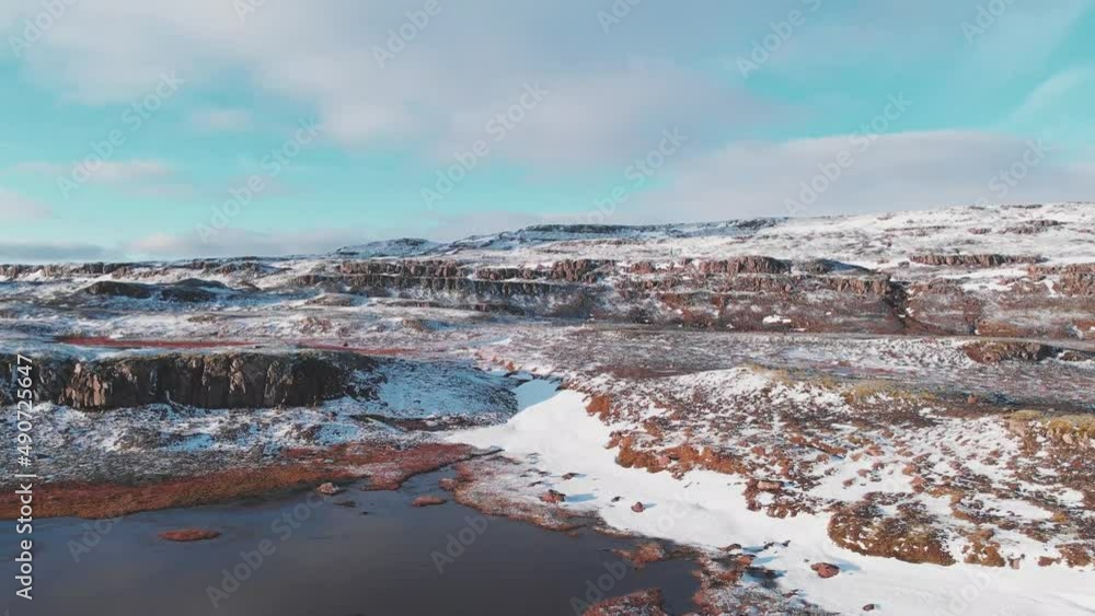 Frozen rocky landscape with glacial pools and snow in Iceland, drone.