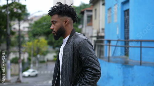 A pensive young black man walking outside in urban street a thoughtful African person