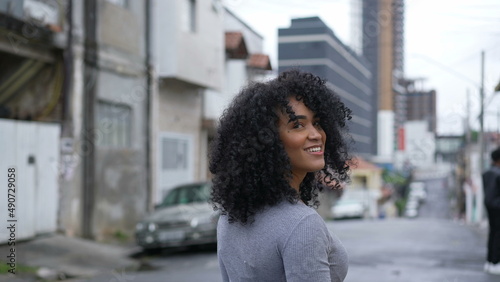 A happy Brazilian woman turning towards camera smiling © Marco
