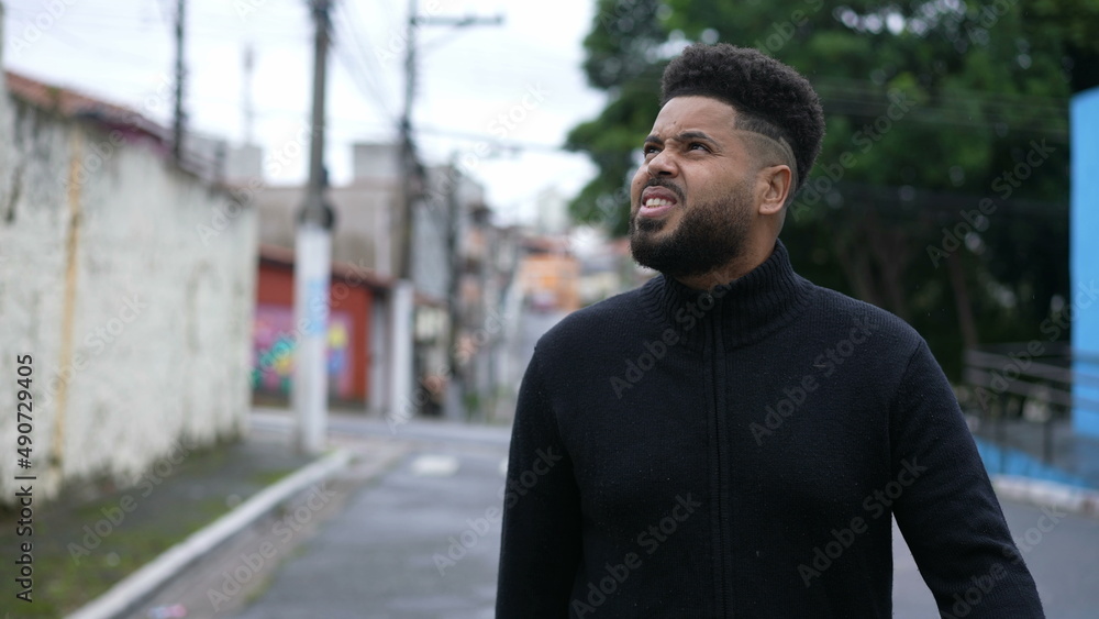 A diverse young black man walking forward in urban street A diverse young black man walking forward in urban street