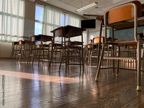 Japanese public school classroom with wooden chairs and desks. 