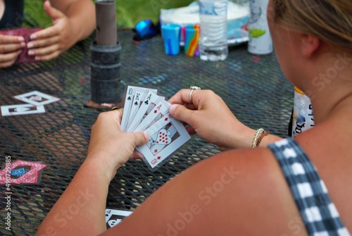 Over the shoulder view of a young woman playing cards