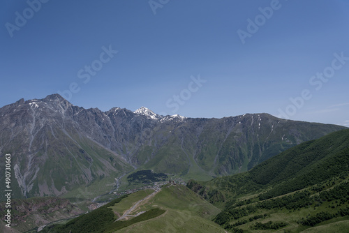 The mountain ranges of Georgia, Kazbegi, where two mountains form a triangular shape and above them a mountain spice that is covered with white snow © Rolands