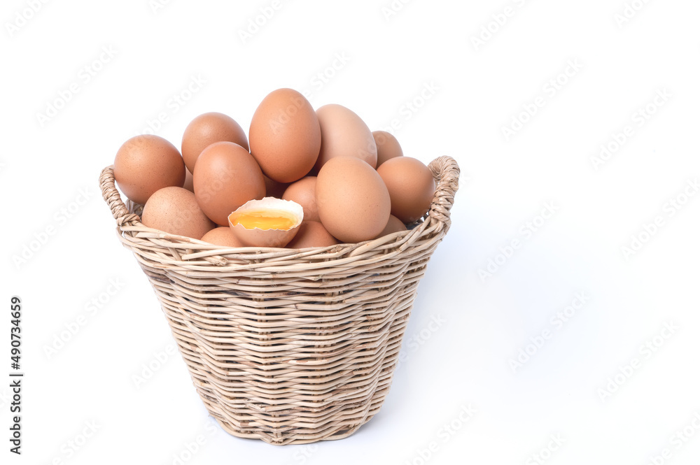 Fresh eggs collected inside wicker basket and one broken, suitable as a food ingredient. Fresh eggs from quality organic farms isolated on white background. Healthy food concept Fresh eggs collected inside wicker basket and one broken, suitable as a food ingredient. Fresh eggs from quality organic farms isolated on white background. Healthy food concept