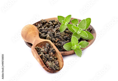 Heap of dry green tea and fresh peppermint on background, isolated on white. Fresh lemon balm leaves, melissa isolated on white background.