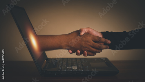 business communication marketing concept handshake teamwork Doing business online, hand in hand with business.Businessman's hand holding a laptop online