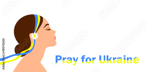 Pray for Ukraine. A girl in a blue and yellow ribbon prays for peace in Ukraine