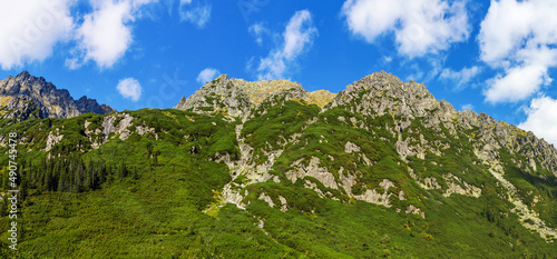 Panorama szczytów Wielki Wołoszyn, Pośredni Wołoszyn i Skrajny Wołoszyn, skaliste szczyty pod błękitnym niebem, Tatry polskie