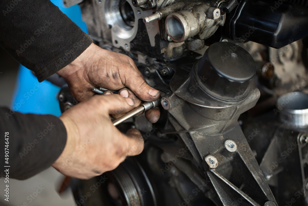 Auto mechanic checking an internal combustion engine Auto mechanic checking an internal combustion engine