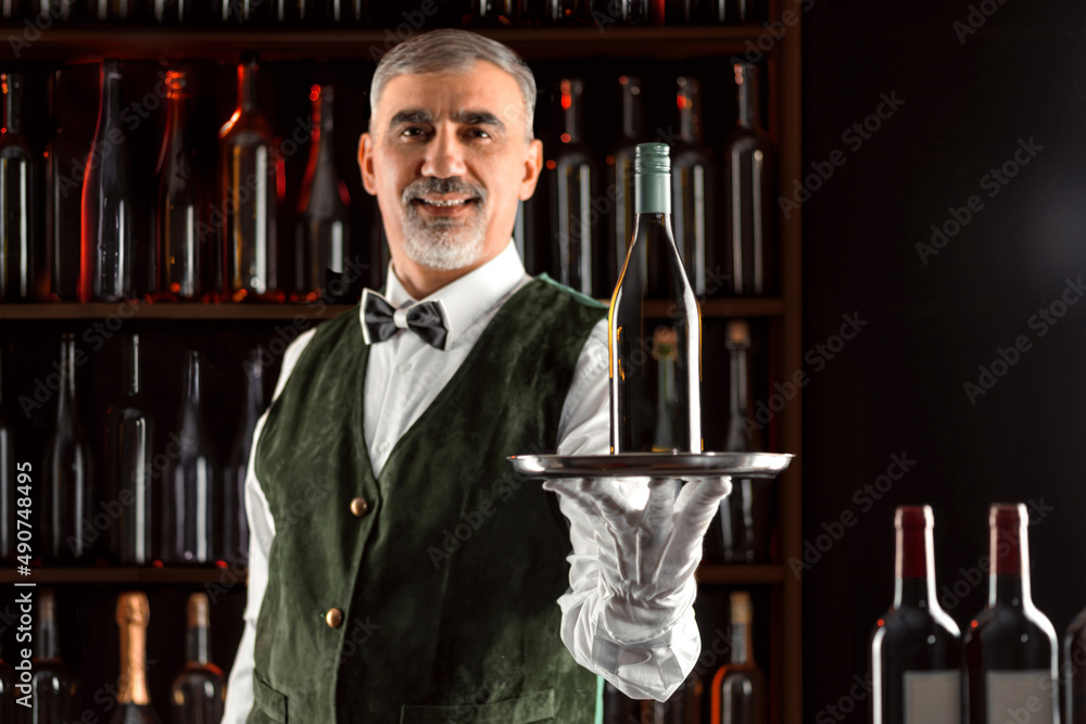 Sommelier wine steward with a bottle of wine. Examination of wine