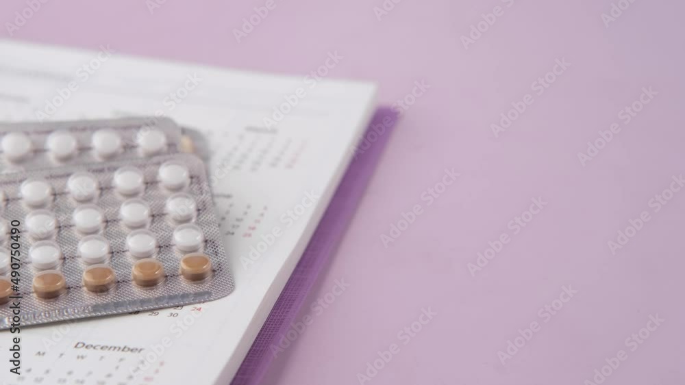 birth control pills , calendar and notepad on table birth control pills , calendar and notepad on table