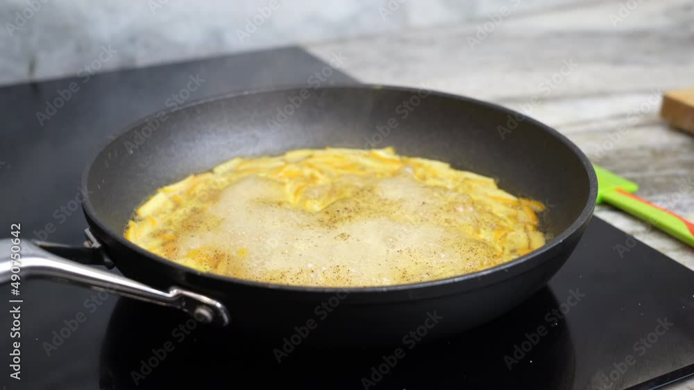 frying pan on a ceramic hob with evaporating slices of orange citrus peel for making sauce for meat frying pan on a ceramic hob with evaporating slices of orange citrus peel for making sauce for meat