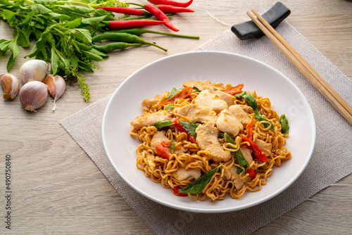 Obraz na plátně Spicy stir fried instant noodle with sliced chicken breast and thai basil leaves