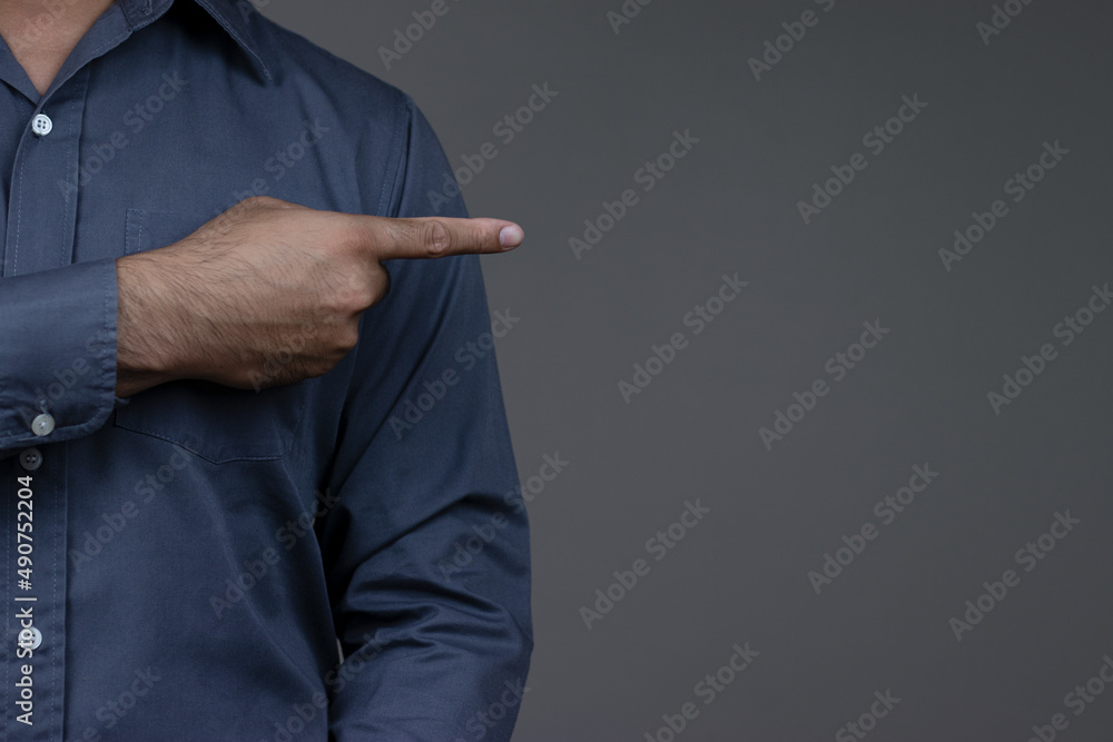 Close-up of business man's hand pointing finger at empty space for text, copy space, Businessman pointing finger on gray background.
