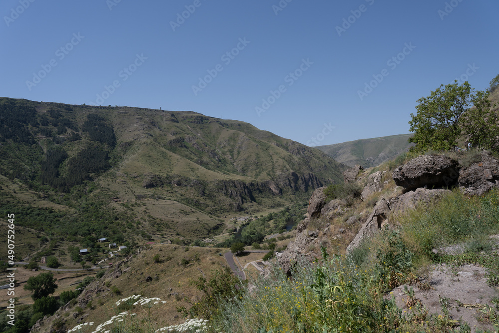 monastery in the mountains of georgia where there are caves and passages along the mountain, above them there is a blue sky.