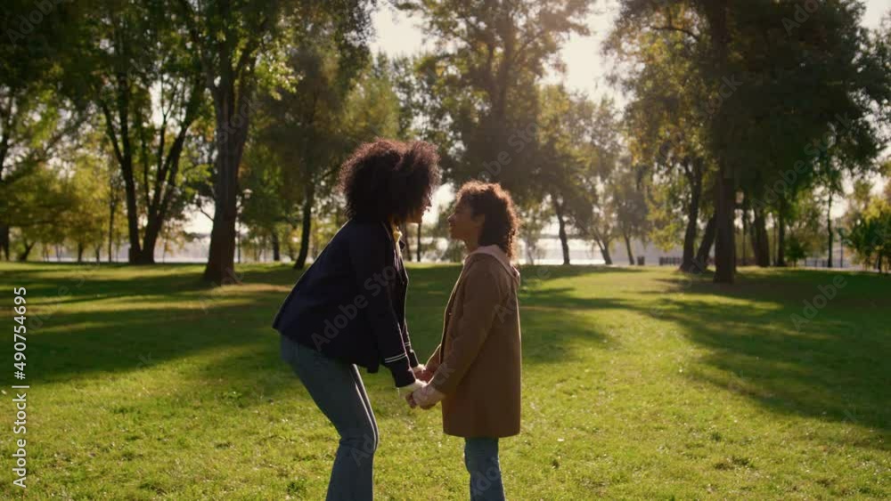 Family touching noses holding hands together in golden sunlight park closeup. Family touching noses holding hands together in golden sunlight park closeup.
