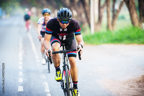 cyclist leads in action,Front view man riding bicycle in the racing road © pixfly