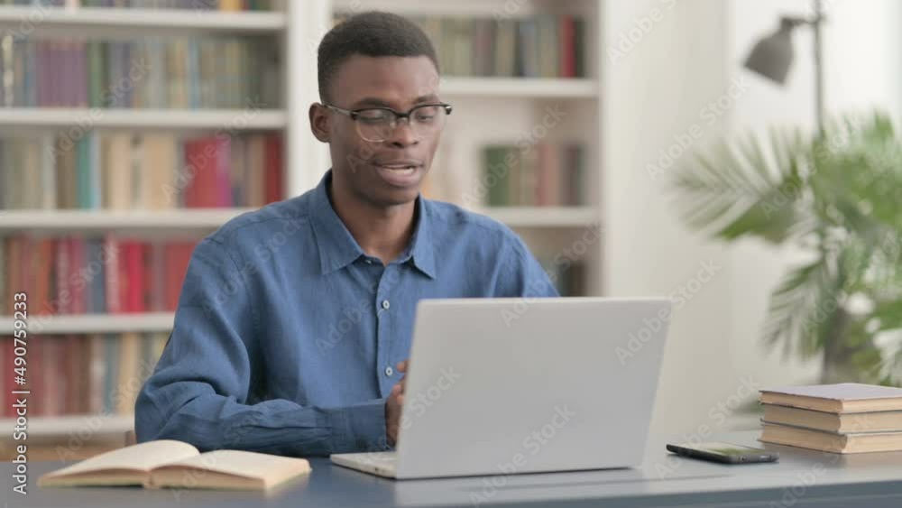 Young African Man Talking on Video Call on Laptop in Office Young African Man Talking on Video Call on Laptop in Office