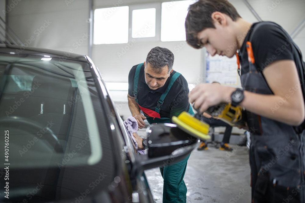 Man works in car polish center. Man works in car polish center.
